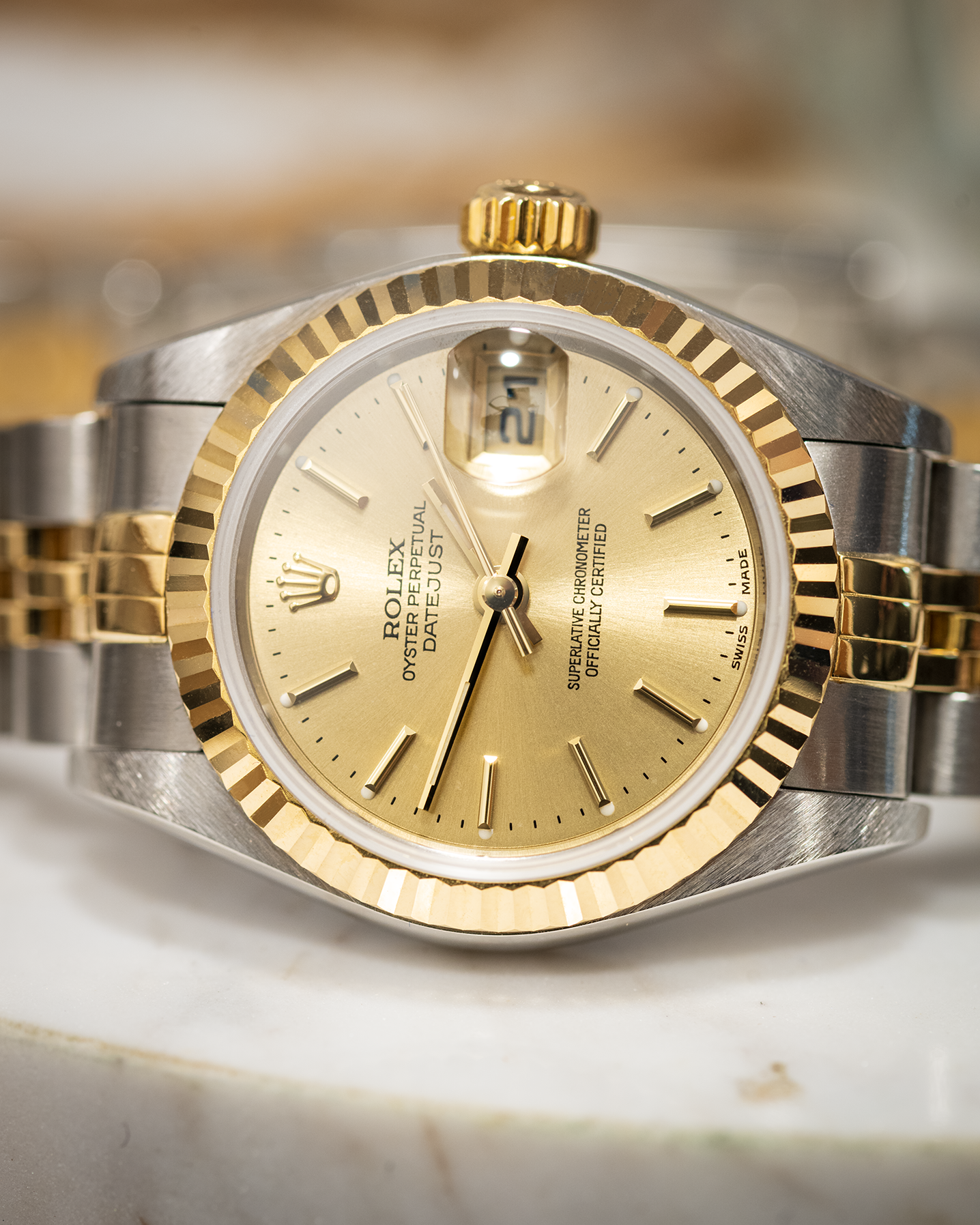 a bi metal rolex datejust with champagne dial photographed on its side