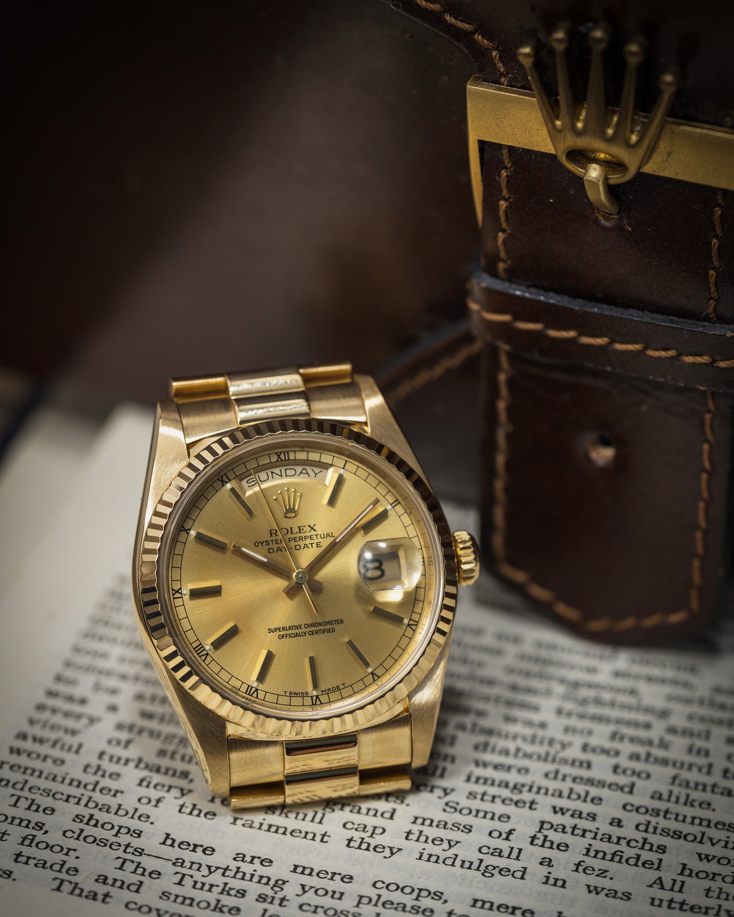 Rolex Day-Date in 18ct Yellow Gold on an open book photographed next to the box