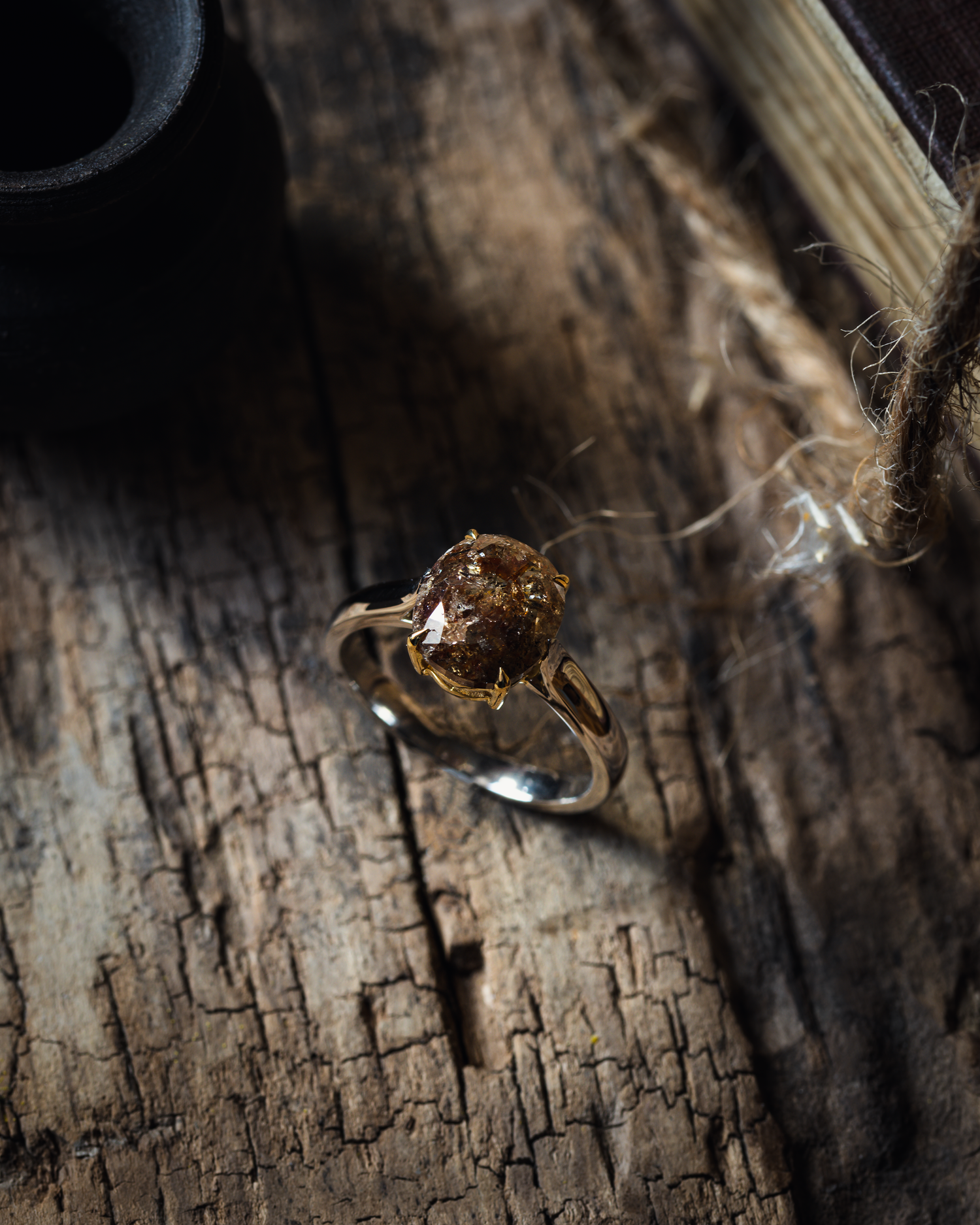 a salt and pepper diamond set in to a talon claw setting